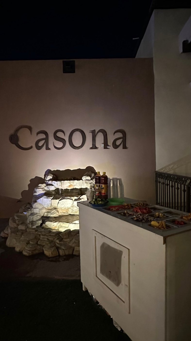 El letrero iluminado de Casona sobre el bar de piedra